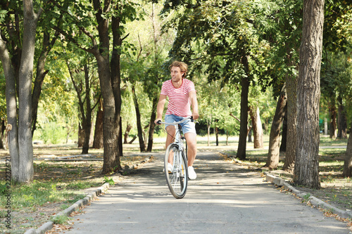 Wallpaper Mural Handsome man riding bicycle in park on sunny day Torontodigital.ca