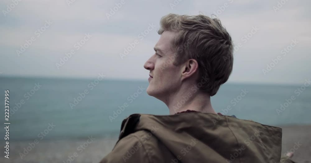 Millennial male enjoying the fresh air on a beach in winter