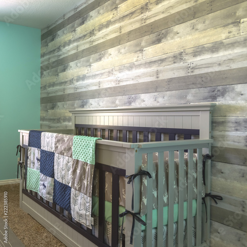 Wooden crib draped with quilt inside a nursery