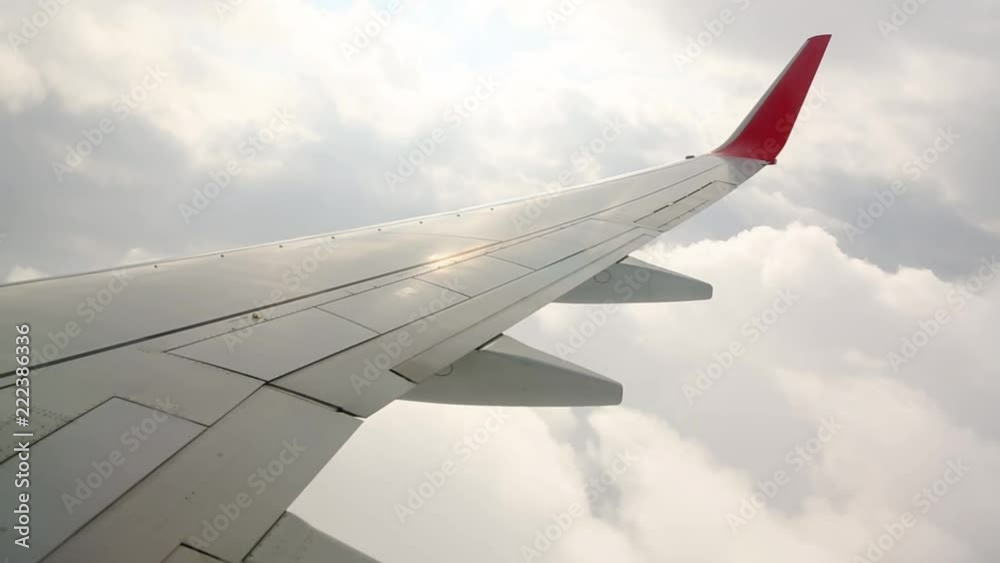 Wing of an airplane in the sky. The plane flies through the clouds Wing of an airplane in the sky. The plane flies through the clouds