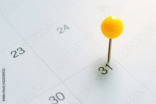 Yellow color pin pinning on the calendar