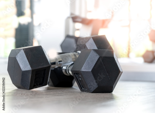 Dumbbell on the floor in fitness room at the morning using depth of field effect.