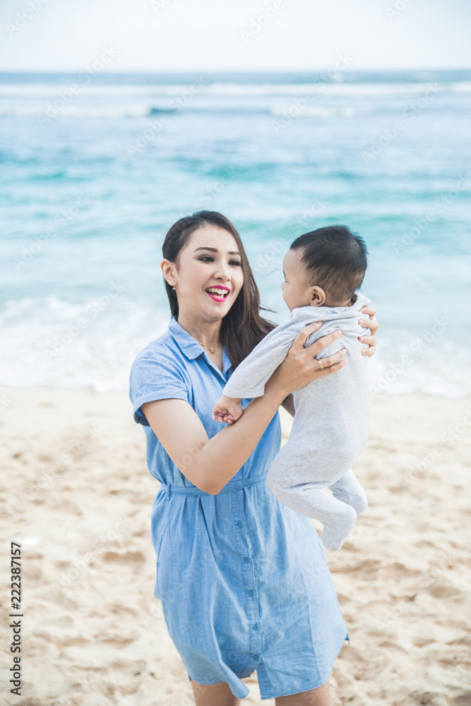 beautiful mom playng with her kids at the beach beautiful mom playng with her kids at the beach