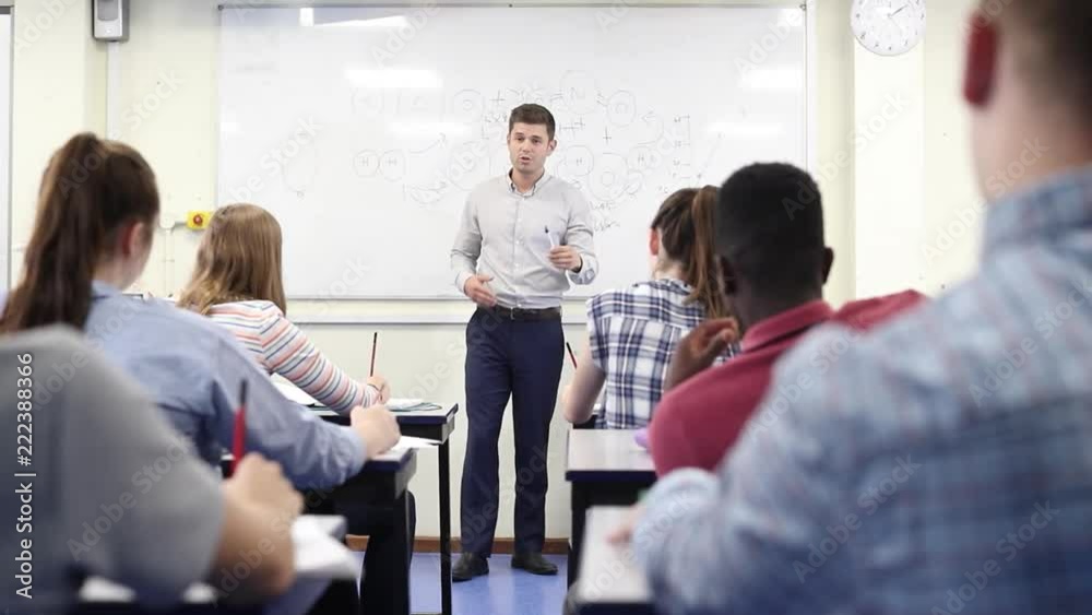 Male High School Tutor At Whiteboard Teaching Science Class Male High School Tutor At Whiteboard Teaching Science Class