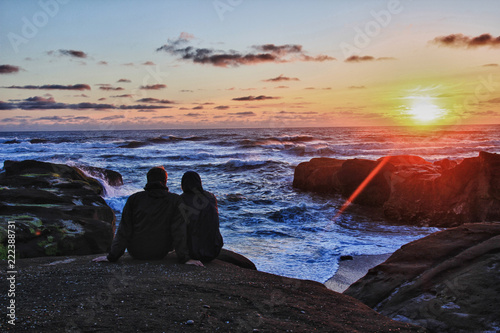 Couple Watching Sunset by the Ocean