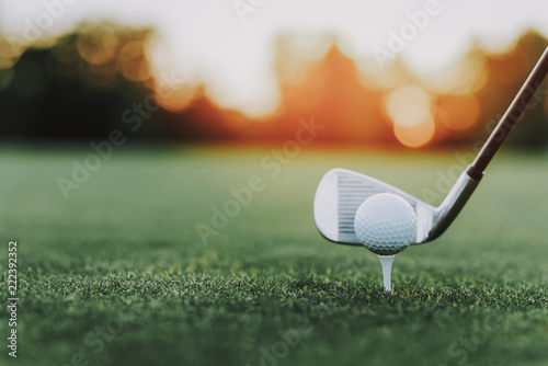 Fototapeta Kij golfowy i piłka golfowa na stojaku na zieleni polu.