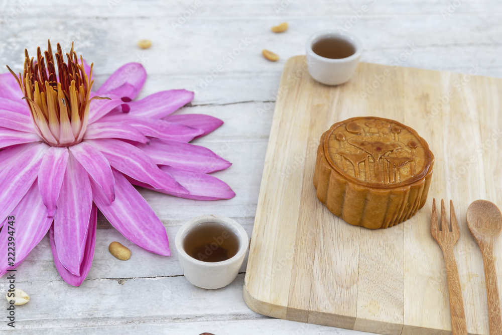 Flat lay of Mid Autumn festival Moon cake on old white table with pink water lily 