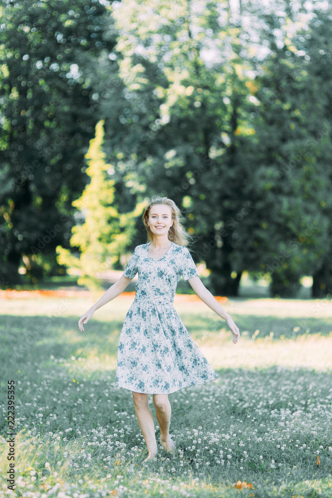 beautiful girl in the Park, in a summer dress and walking. Smiles and enjoys nature. St. Petersburg, Yelagin island