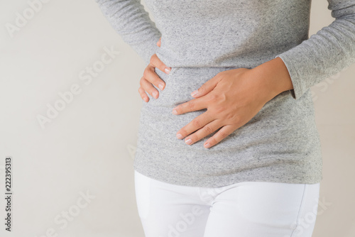 Young woman having painful stomachache. Chronic gastritis. Abdomen bloating concept. photo