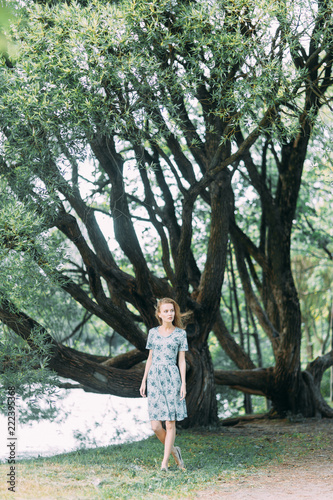 beautiful girl in the Park  in a summer dress and walking. Smiles and enjoys nature. St. Petersburg  Yelagin island