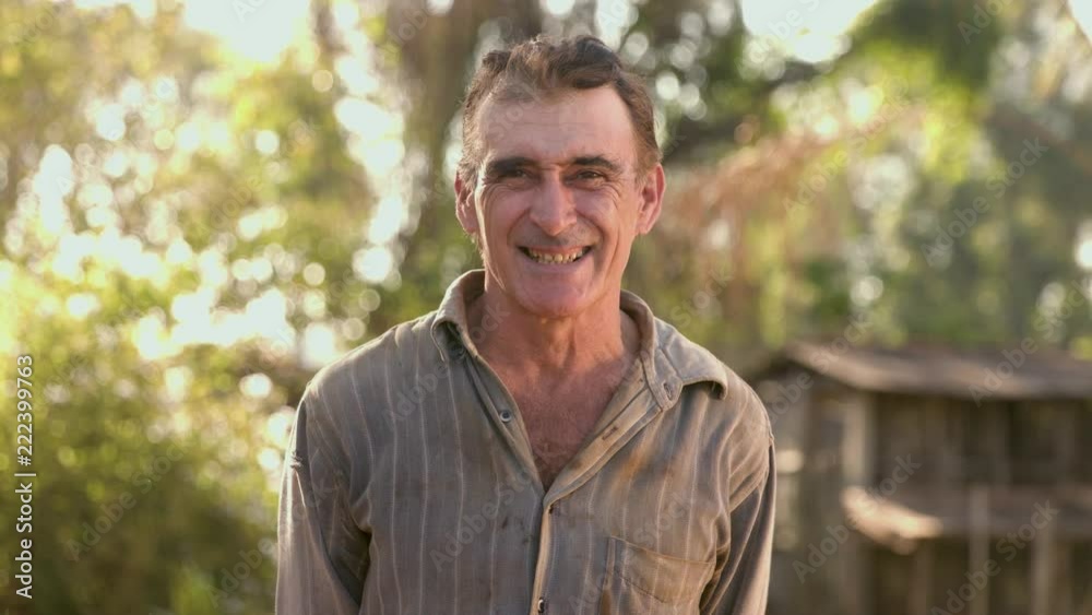 Middle aged farmer on farmland smiling looking at the camera Middle aged farmer on farmland smiling looking at the camera