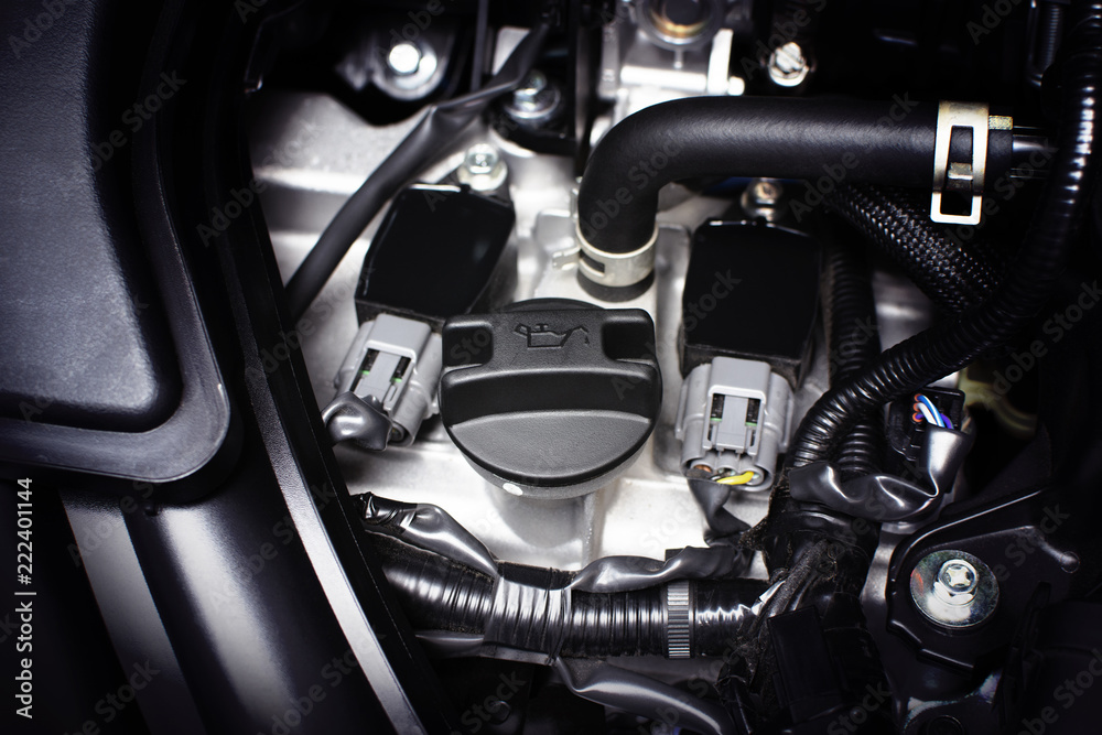 Engine oil cap installed on a car engine for maintenance service lubricant, automotive part concept.
