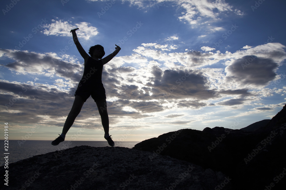 Woman jumping on cliffs in sunset Woman jumping on cliffs in sunset