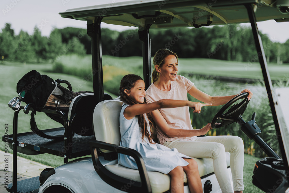 Young Mother and Daughter with Cart on Field.