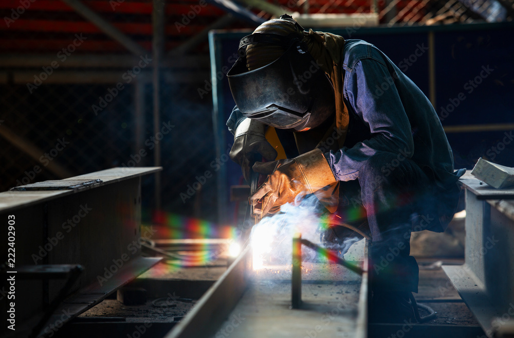 Asian Welder Industry with Torch and Protective Helmet in Large Welding Section Asian Welder Industry with Torch and Protective Helmet in Large Welding Section