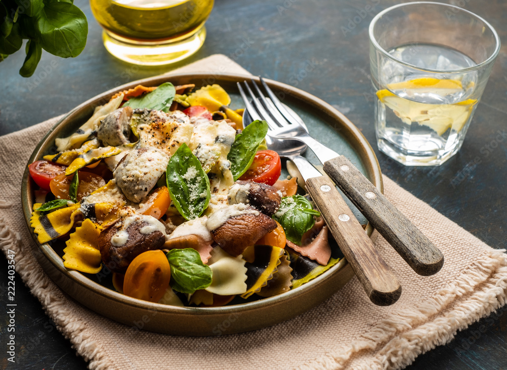 Pasta Farfalle with mushrooms, basil, tomatoes and cream sauce. Italian traditional cuisine. Mediterranean food