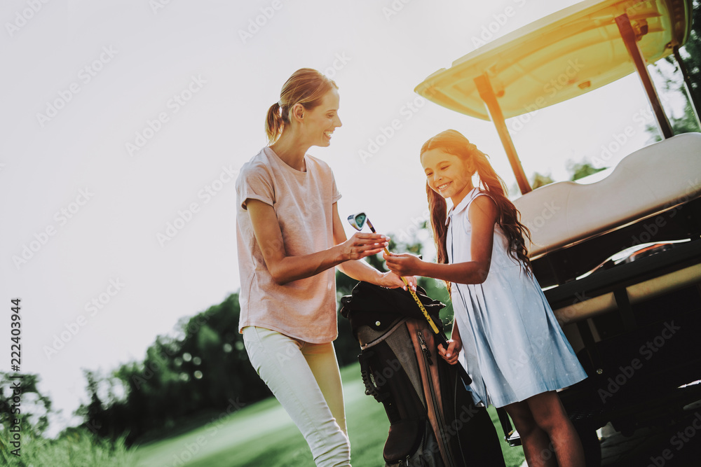 Young Mother and Daughter with Cart on Field.