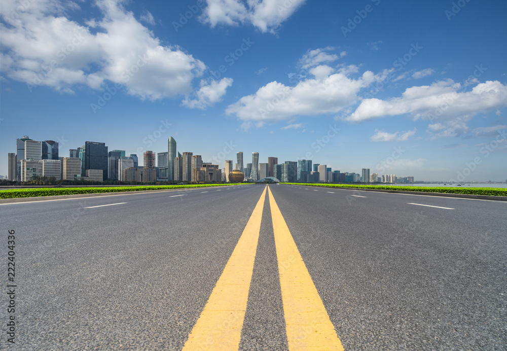 clean asphalt road through the city skyline