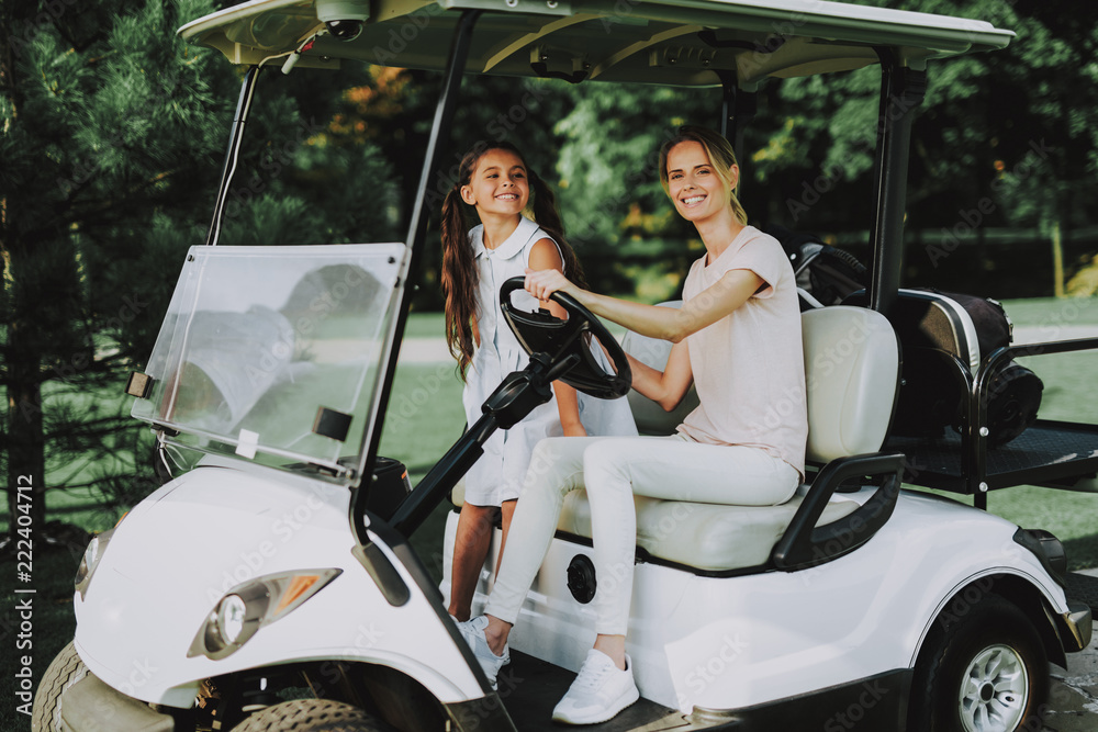 Young Mother and Daughter with Cart on Field.