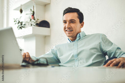 Great mood. Nice positive man smiling while being at work in the office