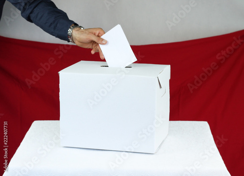 Mężczyzna oddający głos do urny wyborczej © katherine_gee