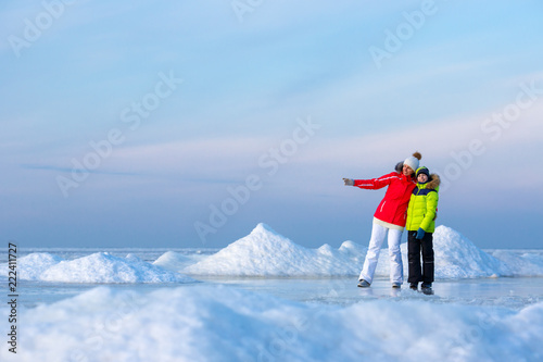 Young mother and her son on icy beach