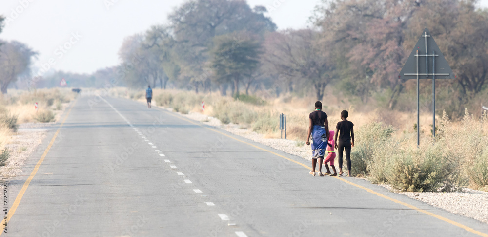 Obraz premium People walking at the side of the road