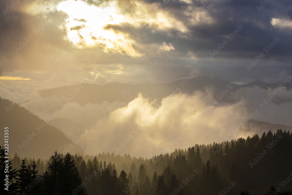 Dramatic rain clouds and thick mist at sunset, in the mountains, in summer Dramatic rain clouds and thick mist at sunset, in the mountains, in summer