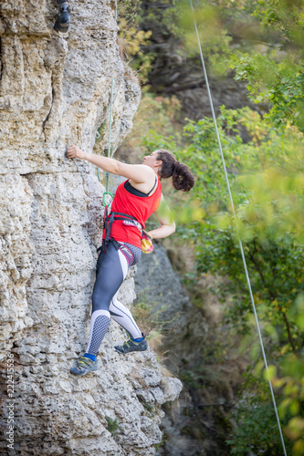 Photo of athlete girl clambering over rock