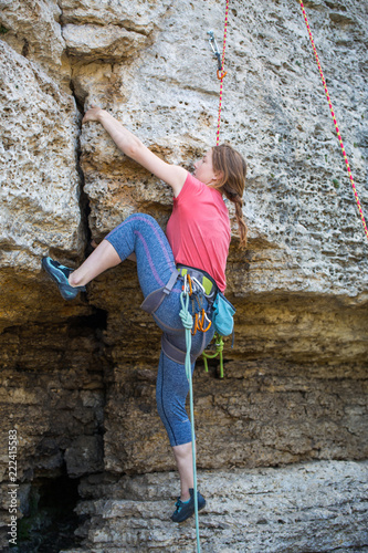 Photo of athlete girl clambering over rock