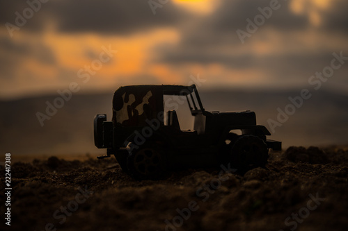 Military silhouettes fighting scene on war fog sky background, Fighting silhouettes Below Cloudy Skyline At sunset. Battle scene. Army jeep vehicle © zef art
