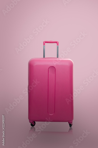  Traveler pink suitcase or cabin size luggage on pink background with shadow, Journey and travel concept