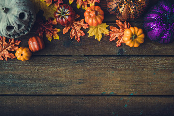 Creative autumn Halloween layout with various leaves and pumkins on dark wooden backgound. Flat lay.