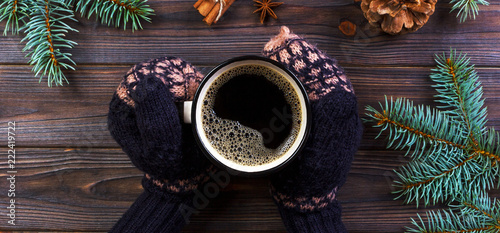 Woman hands holding coffee mug, with with christmas tree branches, pine cones, on marble table, top view photo