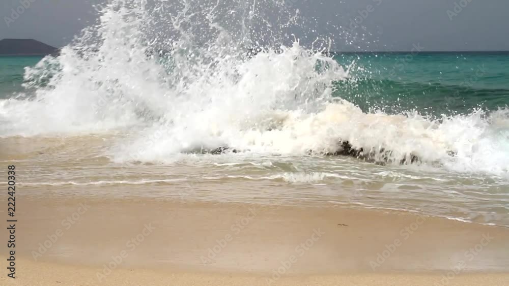 Waves crashing against the rocks with sea and Mountain view Waves crashing against the rocks with sea and Mountain view