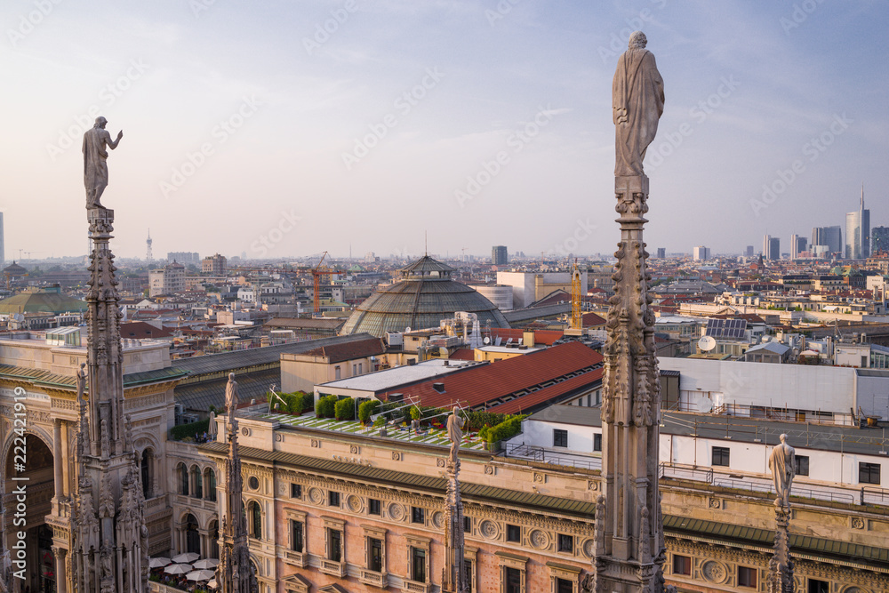 Rooftop view of spires, sculpture, cathederal, and Milan from the Duomo di Milano at sunset