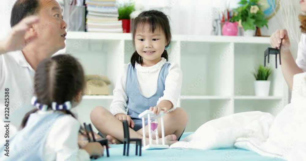 Happy asian family with two daughters playing at home. Family sitting on floor and playing together. Happy asian family with two daughters playing at home. Family sitting on floor and playing together.