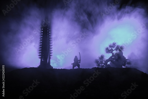 Samurai fighting concept. Silhouette of samurais in duel near tree and old temple. Picture with two samurais and sunset sky. Selective focus