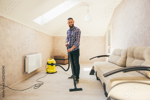 Young bearded man makes cleaning the house