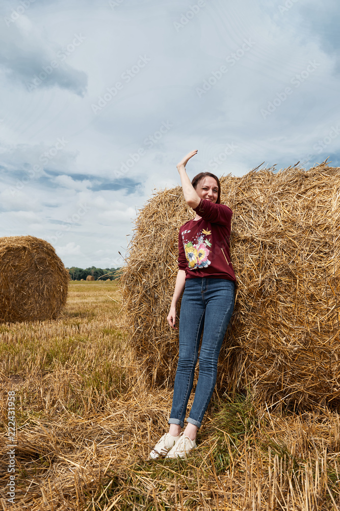 young girl having fun in the field, mowed hay wrapped in a haystack young girl having fun in the field, mowed hay wrapped in a haystack