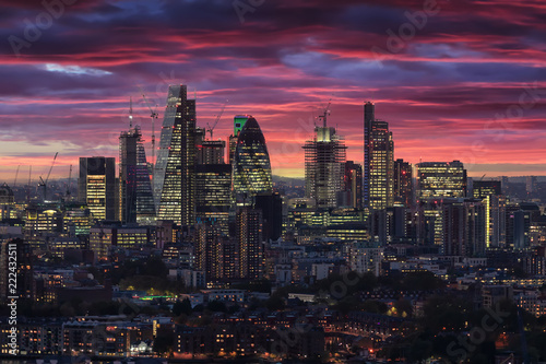Die beleuchtete City von London nach Sonnenuntergang am Abend mit rotem Himmel und Wolken, Großbritannien