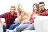 group of happy young people sitting on the couch