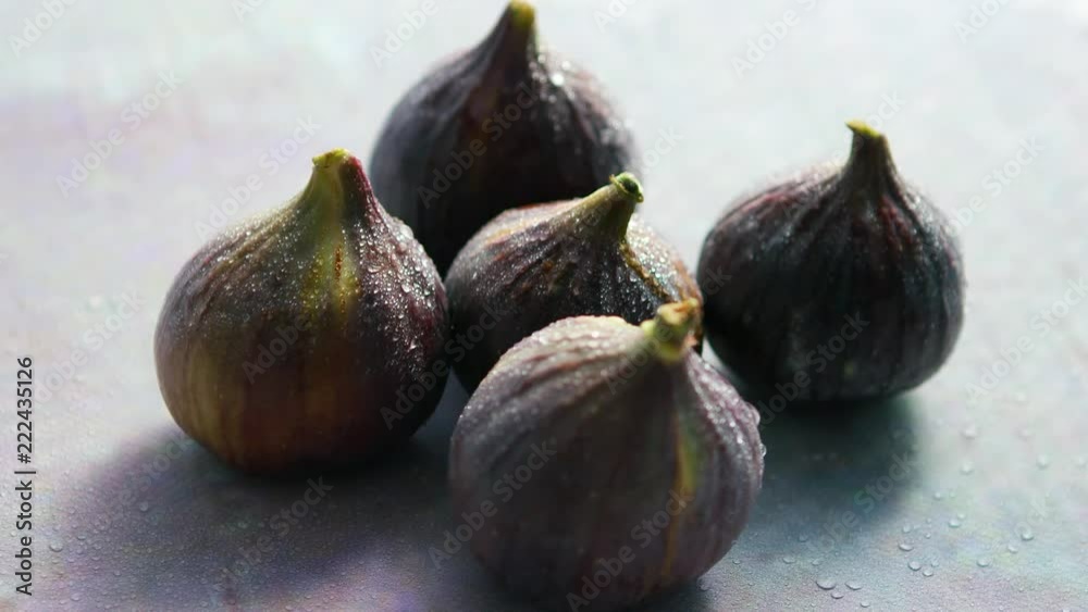 From above closeup shot of whole fresh figs with water drops on table From above closeup shot of whole fresh figs with water drops on table
