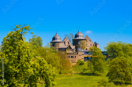 Great view of the west side of Sababurg also known as the Sleeping Beauty Castle, lying on a hilltop in the magnificent forest Reinhardswald in North Hesse, Germany.