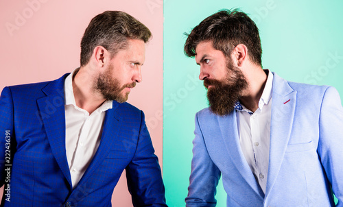 Business competition and confrontation. Businessmen stylish appearance jacket pink blue background. Tense face expression competitors. Business partners competitors in suits with tense bearded faces