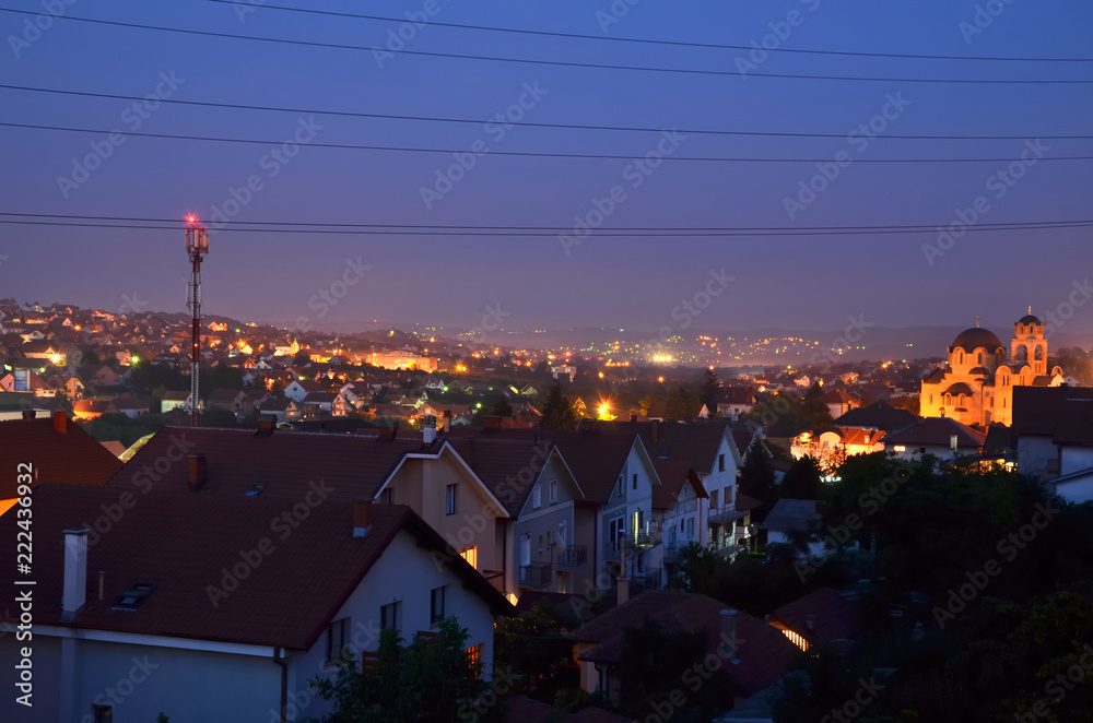 Houses with red roofs in suburban area while night is falling