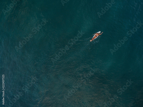 surfer canggu bali aerial shot paddle surf lonely surfergirl