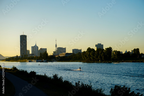 Wakesurfing on Danube and view on Wien. Concept of river water sport in Europe and summer vacations in Austria. photo