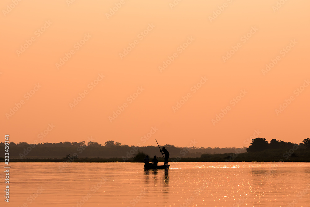 Men in a boat on a river silhouette