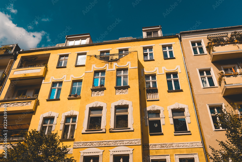 yellow apartment building with white ornaments and darken sky